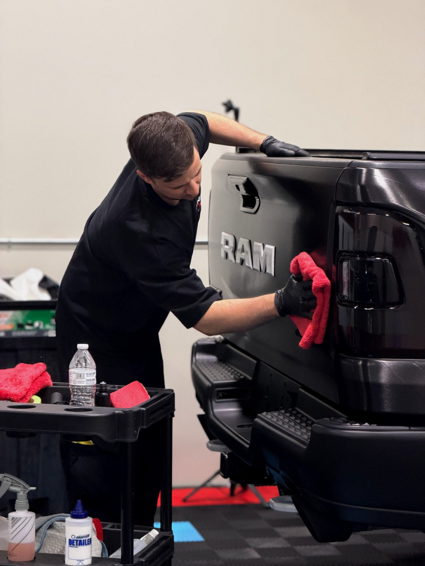 Final Touch Auto Works technician buffing the tailgate of a black Ram truck