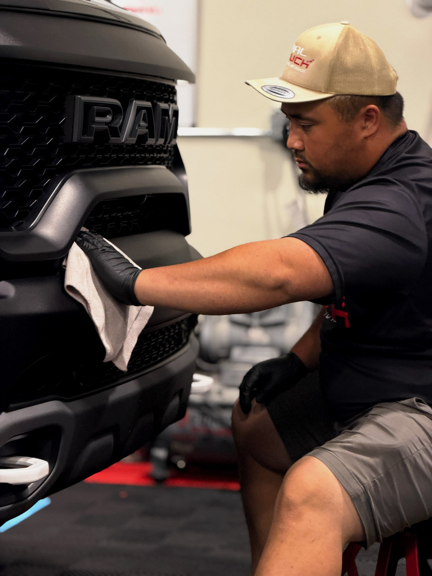 Final Touch Auto Works technician coating the front bumper of a Ram truck